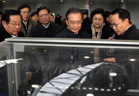 Chinese Premier Wen Jiabao (C) listens to introductions at a biologic products research and development corporation during his visit to Beijing-based Zhongguancun Science Park, known as China's Silicon Valley, Dec. 27, 2008. Wen visited a number of high-tech companies and met with scientists and officials here Saturday. 
