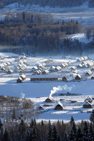 Photo taken on Jan. 4, 2009 shows the scenery of Hemu village of Burqin County in northwestern China's Xinjiang Uygur Autonomous Region. In winter, heavy snow covers trees and hills at the scenic spot of Burqin County.