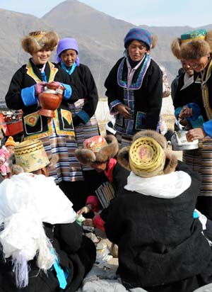 Women present highland barley wine to tractor drivers during a ceremony to mark the start of the spring farming season at Dagze County, southwest China's Tibet Autonomous Region, March 15, 2009. (Xinhua/Chogo)