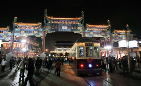 A "Dangdang car", the old-fashioned trolley car, runs on Qianmen Street, one of the old commercial areas of Beijing, capital of China, Oct. 3, 2009. The reopened Qianmen Street attracted a lot of tourists during the National Day holidays, which overlaps the traditional Mid-Autumn Festival this year.(Xinhua/Luo Wei)