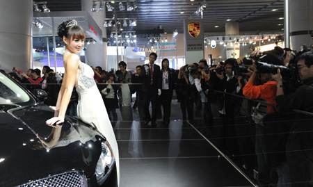 A model stands next to a Jaguar car during the 7th Guangzhou International Auto Show opened in Guangzhou, south China's Guangdong Province, Nov. 24, 2009. Some 720 automibles from over 60 auto makers are on show.