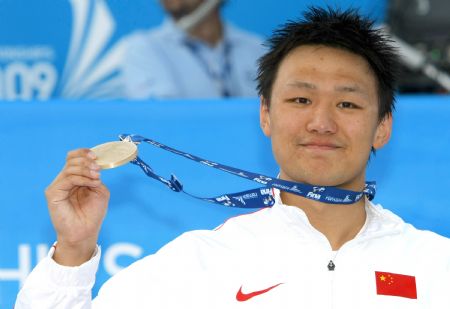 Zhang Lin shows the gold medal after the men's 800m freestyle swimming final at the World Championships in Rome, Italy, July 29, 2009.(Xinhua File Photo)