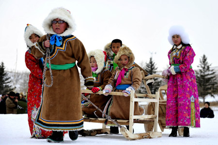 Children of Mongolian ethnic group present traditional clothes in Xi Ujimqin Qi, north China's Inner Mongolia Autonomous Region, on Dec. 28, 2009. Ujimqin grassland ice and snow carnival is opened here on Monday, with many activities including horse-racing, archery, picking things on a running horse and camel-racing, attracting tourists here to taste the unique custom of Mongolian ethnic group. (Xinhua/Ren Junchuan)