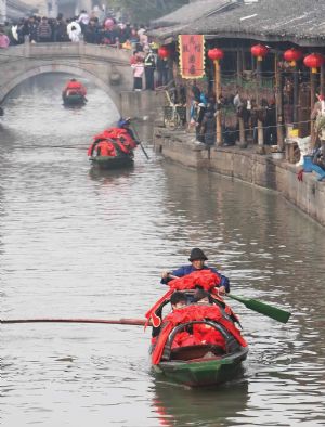 Newlyweds go to the wedding site by black-roof boat in the ancient waterside town of Anchang in Shaoxing City, east China's Zhejiang Province, Jan. 2, 2010. 