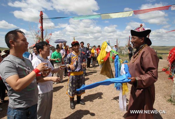 People participate a traditional welcoming ceremony in the Hulunbuir grassland of north China's Inner Mongolia Autonomous Region, July 6, 2010.  The grassland entered the high tourist season recently. (Xinhua/Wang Yongji) (jl) 