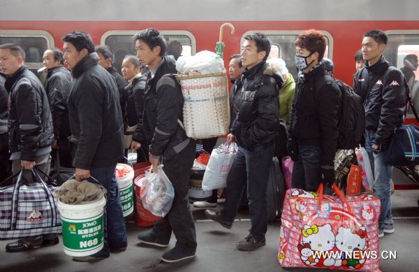 Passengers carrying their luggages prepare to get on the train in the railway station of Hangzhou, capital of east China's Zhejiang Province, Jan. 18, 2011. China's Spring Festival falls on Feb. 3 this year. This year's holiday travel peak will be from Jan. 19 to Feb. 27. Some 230 million trips will be made on China's railway system during the period, up 12.5 percent year on year, according to estimates.  (Xinhua/Ju Huanzong) (zyq) 