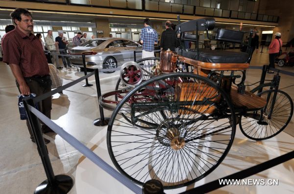 A visitor looks at a model of the automobile made by Carl Benz in 1886 during a Mercedes Benz vintage car show to mark the German car maker's 125 founding anniversary at the former Tempelhof airport in Berlin, Germany, Aug. 28, 2011.  (Xinhua/Ma Ning) (lyi) 
