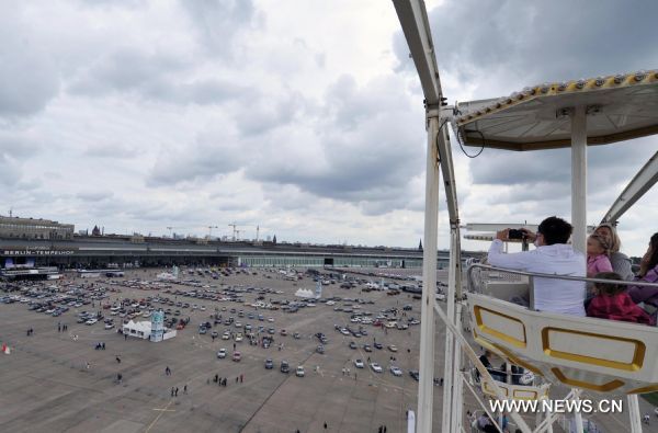 A visitor takes photos during a Mercedes Benz vintage car show to mark the German car maker's 125 founding anniversary at the former Tempelhof airport in Berlin, Germany, Aug. 28, 2011.  (Xinhua/Ma Ning) (lyi) 