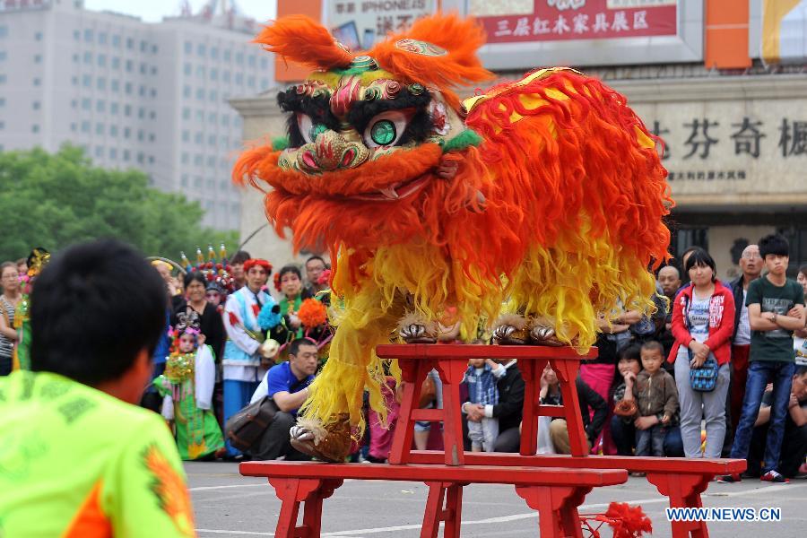 Artists perform lion dance for residents at a square in Taiyuan, capital of north China's Shanxi Province, May 21, 2012. An art performance organized by the local government was presented to citizens here Monday. 