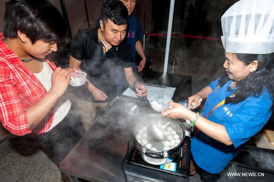 Visitors try Sichuan-style sweet dumplings at the first China Beijing International Fair for Trade in Services (CIFTIS) in Beijing, capital of China, May 29, 2012. Opening Monday in Beijing, the CIFTIS attracted exhibitors of various Chinese cuisines, including the best-known Sichuan, Shandong, Guangdong and Huaiyang cuisines.