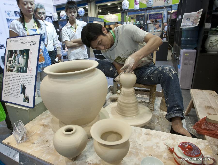 Feng Shaoxing, a pottery craftsman, shows how to throw a body of porcelain at the first China Beijing International Fair for Trade in Services in Beijing, capital of China, May 29, 2012. Chinese intangible cultural heritages were also displayed at the first China Beijing International Fair for Trade in Services, held from May 28 to June 1. 