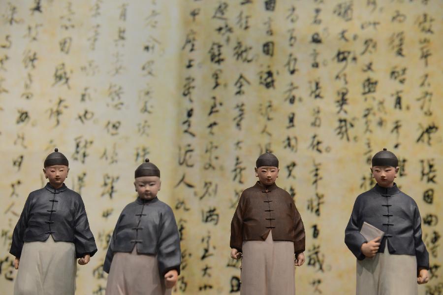 Clay figurines of Qing Dynasty (1644-1911) students in Macao are displayed at an exhibition of the works of Zhang Zexun, the fifth-generation descendant of Tianjin-based clay sculpture art Clay Figure Zhang, in south China's Macao, Jan. 4, 2013. The exhibition will be held at the UNESCO Centre of Macao from Jan. 4 to 13. (Xinhua/Cheong Kam Ka) 